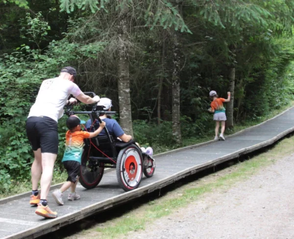 Familie mit Rollstuhl im Wald